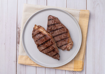 Grilled picanha beefs in a plate over wooden table