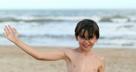 Child boy waving to camera at the beach © Marco