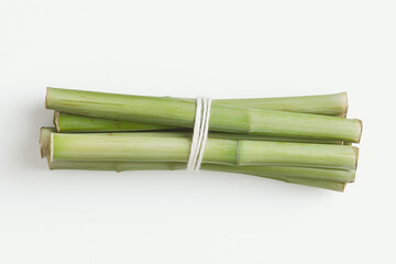 Fototapeta premium Bundle of Fresh Lemongrass: A bunch of fresh lemongrass stalks, tied together with a rubber band, showcasing their vibrant green color and distinct aroma. A perfect image for recipes, culinary arts.