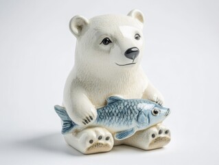 Pottery of a polar bear and fish. Polar bear holding a fish on its lap.