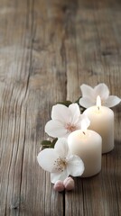 Softly glowing candles surrounded by pink flowers create a calming ambiance on a wooden surface, perfect for relaxation or decor