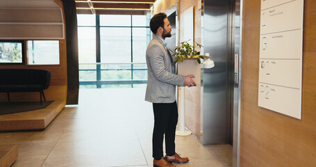 Business, man and elevator with box for dismissal, fired and retrenched of unemployment. Male person, items and waiting on lift with resignation, corporate bankruptcy and recession notice for jobless © peopleimages.com