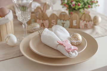 Festive Easter table setting with Easter bunny made from napkin. Easter celebration concept