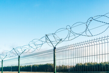Barbed wire fence on sky background. 