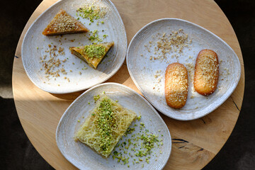 Assortment of pastries including baklava and a shredded filo pastry dessert garnished with pistachios and nuts
