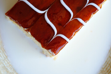 A delectable slice of creamy custard cake topped with a glossy caramel glaze and delicate white swirls