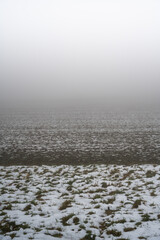 Obraz premium A snowy field with a foggy sky in the background
