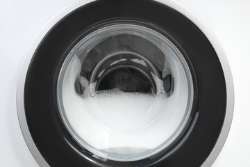 Washing machine with suds as background, closeup