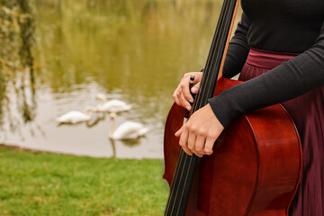 Woman with cello in park, closeup. Space for text