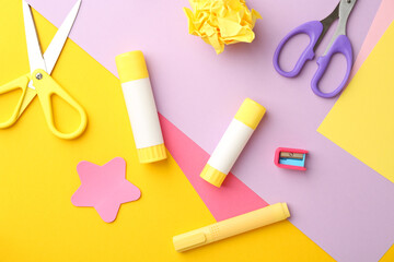 Flat lay composition with glue, scissors and other stationery on color background