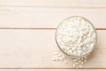 Puffed rice in bowl on white wooden table, top view. Space for text