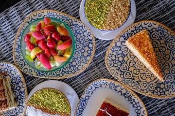 Assorted desserts and fresh fruit displayed on ornate plates