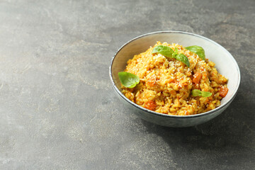 Delicious pumpkin risotto with basil on grey table. Space for text