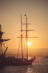 Fototapeta premium Historic Tall Ships along the Harbor at Sunset