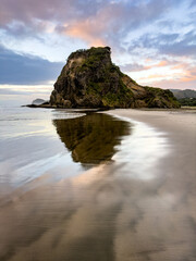 Lion Rock in Piha beach at summer sunset. New Zealand
