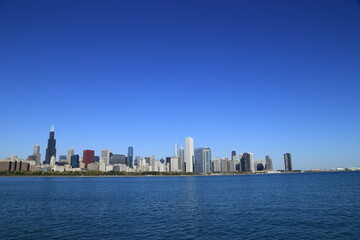 Naklejka premium Chicago skyline across Lake Michigan under clear blue sky