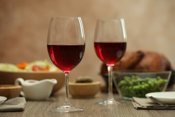 Red wine and delicious dinner served on wooden table