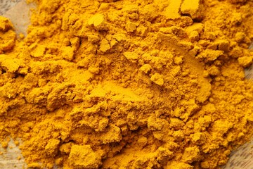 Heap of turmeric powder on table, top view