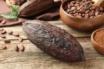 Cocoa pods and beans on wooden table, closeup