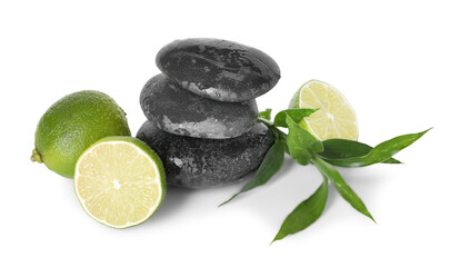 Spa composition with limes, massage stones and green leaves isolated on white