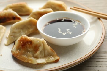 Delicious fried gyoza dumplings served on wooden table, closeup