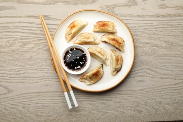 Delicious fried gyoza dumplings served on wooden table, top view
