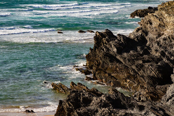 Stunning view of dramatic cliffs and the vast ocean in Porto Covo, Portugal, showcasing the power of nature and the serene beauty of the coastline