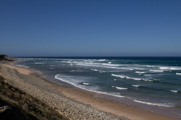 The ocean waves along the Rota Vicentina trail are perfect for surfing, with powerful swells crashing onto the shore. This popular coastal route provides an ideal setting for surfers