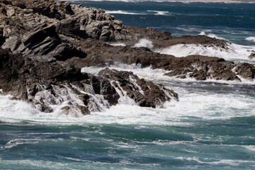 Powerful waves crash against the jagged rocks of Porto Covo's coastline