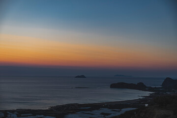Landscape during evening on calm sea with coast