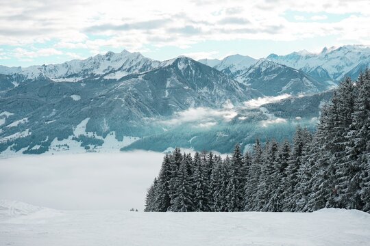Winter landscape with snow-covered trees and mountains

Snow-covered mountains and coniferous forests create a beautiful winter landscape. The cloudy sky and light fog enhance the atmosphere of winter - Powered by Adobe