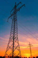 Fototapeta premium Summer sunset with a dramatic sky and overland high voltage lines near Tabertshausen, Aholming, Deggendorf, Bavaria, Germany