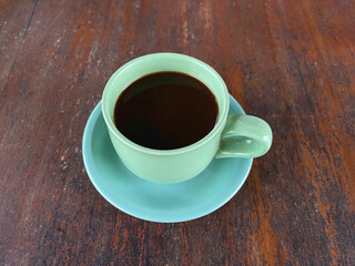 Coffee cup on wooden table background. Top view with copy space.