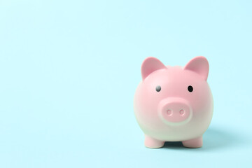Piggy coin bank on colored background for money savings, financial security or personal funds concept.