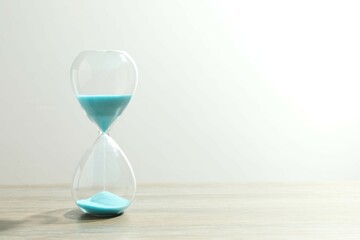 Modern hourglass on the table. Hourglass time concept for business deadline, urgency and outcome of...