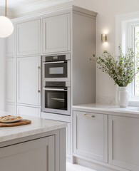 Modern kitchen with light gray cabinetry, built in appliances, and vase of flowers. design features clean aesthetic, perfect for contemporary living
