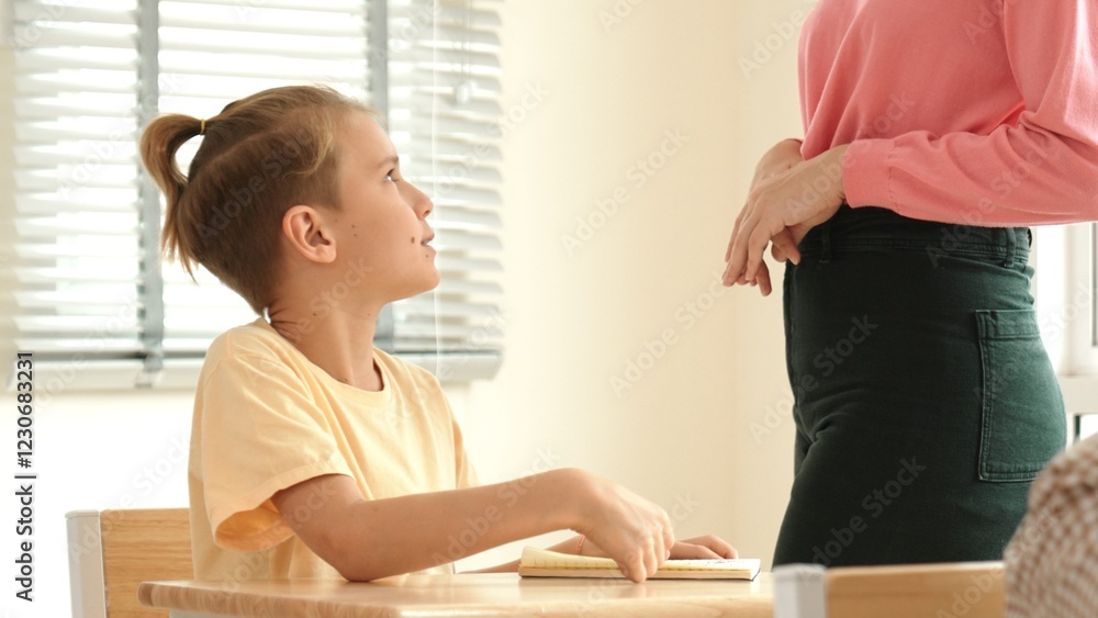 Aufkleber beautiful teacher explaining test while caucasian boy doing classwork and listening explanation. cut