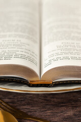 Obraz premium Open holy bible book on plate with golden fork and spoon on wooden table. Close-up. Spiritual food and Christian fasting concept.