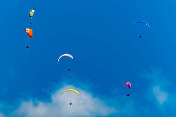 Alpine summer view with lots of paragliders seen from Lake Bannwaldsee, Schwangau, Ostallgaeu, Bavaria, Germany