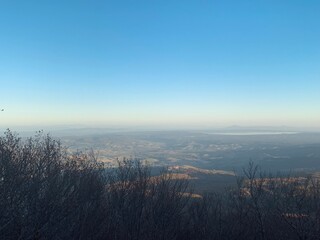 A panoramic view from a hilltop overlooking with a clear blue sky.