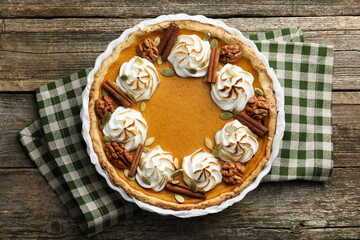 Delicious homemade pumpkin pie in baking dish on wooden table, top view