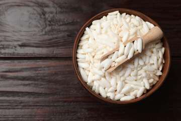 Puffed rice in bowl and scoop on wooden table, top view. Space for text