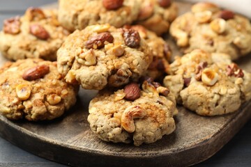 Tasty cookies with nuts on dark wooden table, closeup