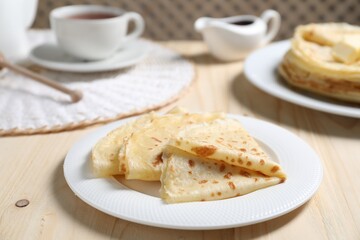 Tasty crepes served on wooden table, closeup