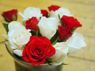 Red and white moss roses (Rosa × centifolia ‚Muscosa’) in a glass vase. Concept: romance, valentine’s day, gift, anniversary, celebration, congratulation,