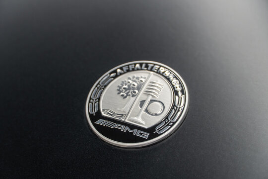 AMG Affalterbach logo on a gray matte background, close-up. AMG Affalterbach nameplate on the hood of the Mercedes-Benz S63 S-class W223 V8 biturbo. The Affalterbach AMG logo on the hood of the W223. 