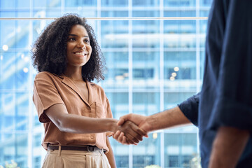 Handshake of happy African business woman and business man meeting in office. Young female bank...