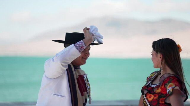 Young dancer wearing traditional chilean huaso clothing performs the national dance, cueca, by the ocean