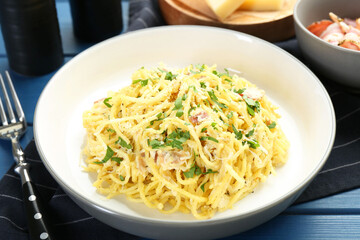 Delicious pasta Carbonara served on blue wooden table, closeup