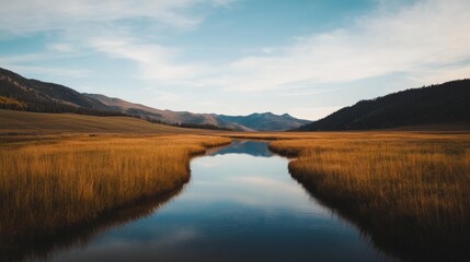 Fototapeta premium Calm river reflecting mountains & sky in autumnal valley.